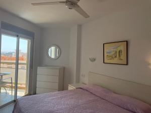 sypialnia z łóżkiem i wentylatorem sufitowym w obiekcie Apartamentos Apal Chinasol w Almuñécar