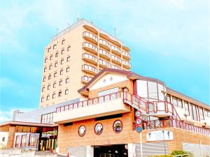 舞鹤市Hotel BELLMARE ホテルベルマーレ的顶部有阳台的高楼