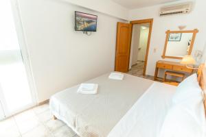 a bedroom with a white bed and a mirror at Kos City Apartments in Kos