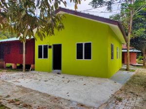 una piccola casa gialla con un rosso di NUR RAMADHAN CAMPSITE a Tanjung Malim