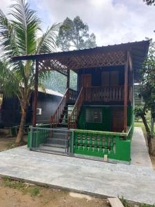 una casa con una escalera delante de ella en NUR RAMADHAN CAMPSITE, en Tanjung Malim