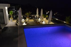 a swimming pool with blue lights on top of a building at Kalamper Apartments in Dobra Voda