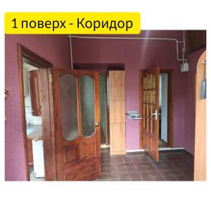 um quarto com duas portas abertas e paredes roxas em Holiday Home u Tetiany em Kamianets-Podilskyi