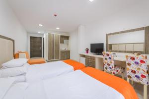 Pokój z 2 łóżkami i biurkiem z telewizorem w obiekcie Hotel & Apartments HEC Residence w miejscowości Sveti Stefan