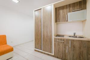 a small kitchen with wooden cabinets and a sink at Hotel & Apartments HEC Residence in Sveti Stefan