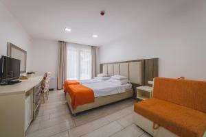 a hotel room with a bed and a chair at Hotel & Apartments HEC Residence in Sveti Stefan