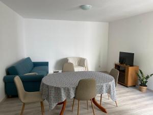 a living room with a table and a blue couch at Rooms Jelena in Dubrovnik