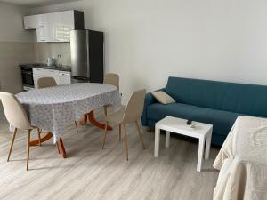 a living room with a blue couch and a table and chairs at Rooms Jelena in Dubrovnik