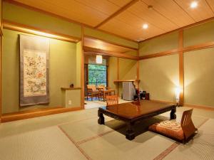 a living room with a table and a dining room at Mizumari in Kawazu