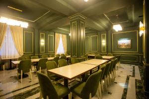 Leon Hotel Spa Ganja في غانيا: غرفة طعام مع طاولات وكراسي خضراء