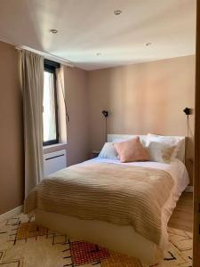 1 dormitorio con cama con almohadas y ventana en La maison d'André, en Le Havre