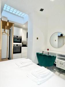 a kitchen with a table and a green chair at Duke and Duchess Apartments and Rooms - Private in Room Hot Tub Suites in London