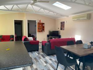 Sabai accommodation في دونغارا: غرفة معيشة مع أريكة وطاولة وكراسي