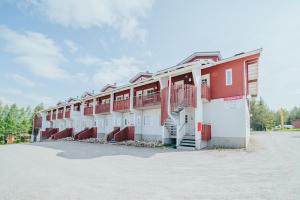 a row of apartment buildings with red and white at Leviloma - 27m2 B - Levi huoneisto loma-asunto Levistar majoitus - Levi apartment Levistar accommodation in Levi