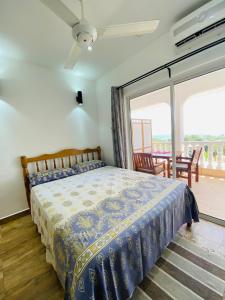 博瓦隆Oceanic View Apartments的带床和滑动玻璃门的卧室