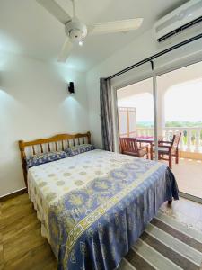 Schlafzimmer mit einem Bett und einer Glasschiebetür in der Unterkunft Oceanic View Apartments in Beau Vallon
