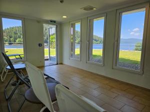 a dining room with windows and a table and chairs at Seehotel Hubertus in Schluchsee +31 photos