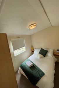 a bedroom with a bed and a window in it at New Beaches: Butternut in Dymchurch