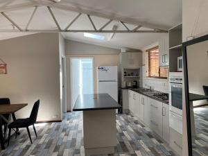 a kitchen with white cabinets and a black counter top at Sabai accommodation in Dongara
