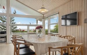 comedor con mesa, sillas y TV en Beautiful Home In Bjert With Kitchen, en Sønder Bjert
