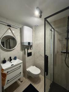 y baño con aseo, lavabo y ducha. en Apartamenty Wypoczynkowa 3, en Rowy