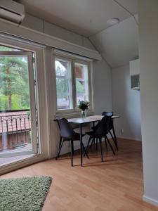 a dining room with a table and chairs and a window at Villa Sammalpankko in Kuopio