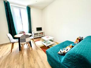 a bedroom with a bed and a table with chairs at Le Gamay - Charmant T2 avec parking et Terrasse in Châtel-Guyon