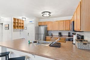 a kitchen with wooden cabinets and a stainless steel refrigerator at First Tracks 3301 Condo in Steamboat Springs