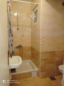 een badkamer met een douche, een bad en een wastafel bij Apartments Panorama in Korčula