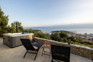 a hot tub and two chairs sitting on a stone wall at Tiny house Aria in Makarska