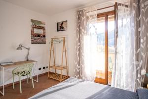 a bedroom with a bed and a desk and a window at Casa Furia in Ponte della Venturina