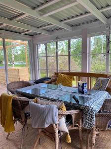 un porche cubierto con mesa y sillas en Summer Cottage with boat, en Hudiksvall