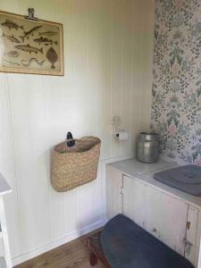 Summer Cottage with boat في هوديكسفال: ركن من المطبخ مع سلة على الحائط