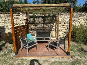 2 Stühle und ein Tisch auf einer Holzterrasse in der Unterkunft La Barbacane in Sigean