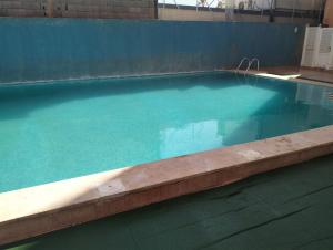 een groot zwembad met blauw water in een gebouw bij appartement a Marrakech in Marrakesh