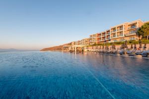 un grande bacino d'acqua accanto a un edificio di Michelangelo Resort & Spa ad Ágios Fokás