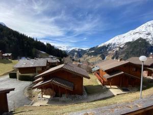 un gruppo di edifici con montagne sullo sfondo di Chalet Cannon- Mountain Getaway a Les Contamines-Montjoie