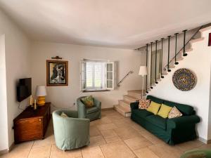 里帕貝拉的住宿－Podere Terraviva，一间带两把椅子和楼梯的客厅