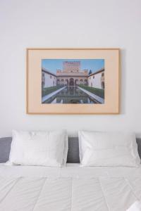 a picture above a bed in a bedroom at Slow Sevilla suite - two-bedroom apartment with private pool in Seville