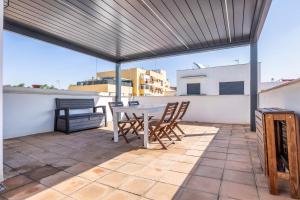 a patio with a table and chairs on a roof at Slow Sevilla suite - two-bedroom apartment with private pool in Seville