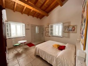 a bedroom with a bed and a table and windows at Podere Terraviva in Riparbella