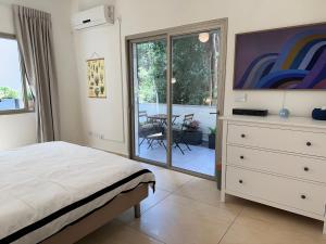 a bedroom with a bed and a dresser and a table at Roza Apartment in Tel Aviv