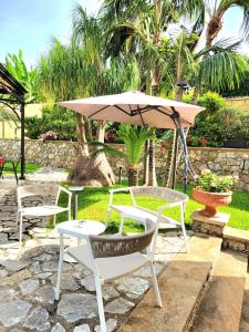 a patio with two chairs and an umbrella at Hotel Garibaldi in Milazzo