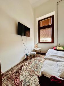 een slaapkamer met een bed en een tv aan de muur bij Apartman Katedrala in Sarajevo