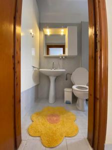 bagno con lavandino, servizi igienici e tappeto di Loft Oasis a Hanioti