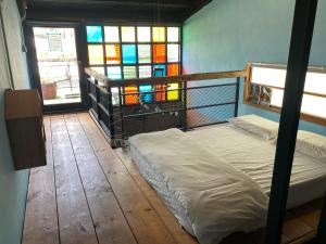 a bedroom with a bed and stained glass windows at Lucky 1960 in Tainan