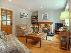 a living room with a couch and a fireplace at Pond View Cottage in Brantingham