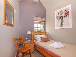 Brantingham的住宿－Pond View Cottage，一间卧室配有一张床、一张桌子和一把椅子