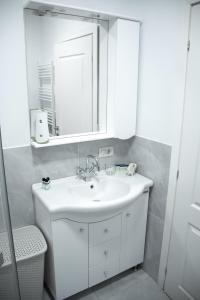a bathroom with a white sink and a mirror at Nordic Residence 1 in Suceava