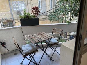 a wooden table and two chairs on a balcony at Roza Apartment in Tel Aviv